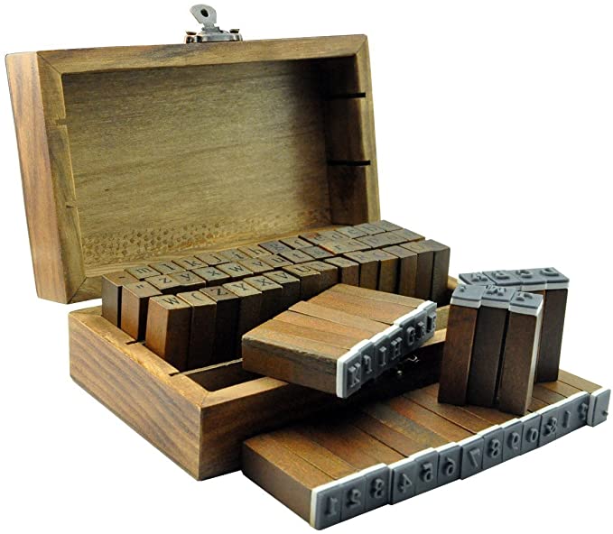A wood box full of alphabet and other character symbol stamps.